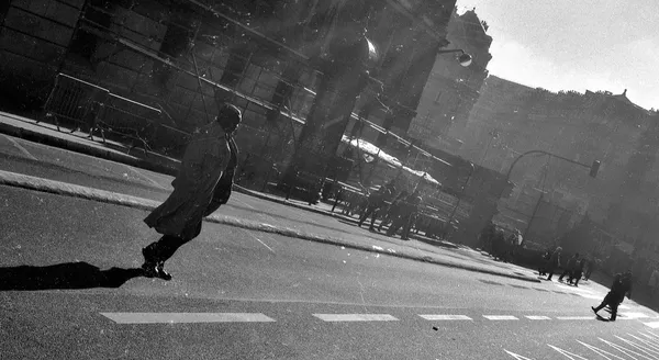 A figure appears to float across a sunlit Parisian street, reflections and backlighting creating a dreamlike double exposure effect