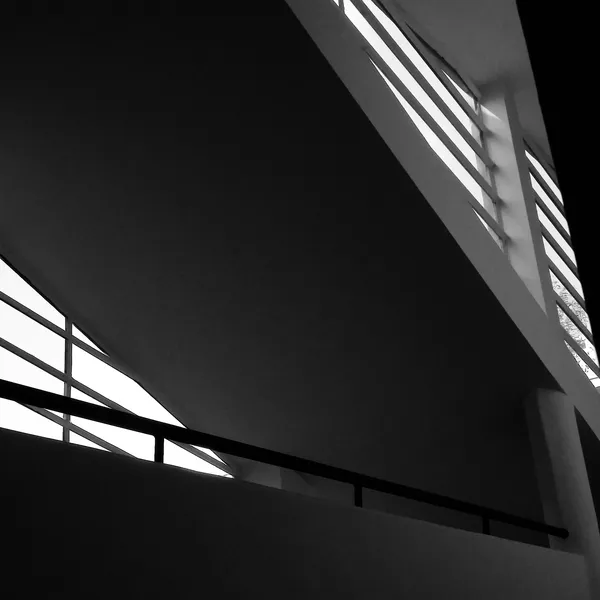 Dramatic low-angle view of Villa Savoye's horizontal window bands glowing against deep shadow, a minimalist architectural abstraction in Poissy