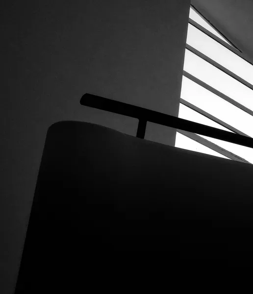 A handrail and window slats inside Villa Savoye, light slicing through modernist geometry in this abstract architectural study of Le Corbusier's masterpiece