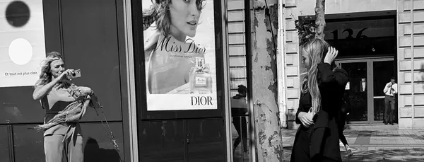 Two women mirror a Dior advertisement on a Parisian boulevard, reality and fantasy blurring in this witty street photography triptych