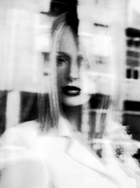 A woman's face dissolves behind layers of motion blur and grain, lips and hair emerging from abstraction in this haunting experimental portrait